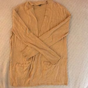 Light brown/gold-ish cardigan.